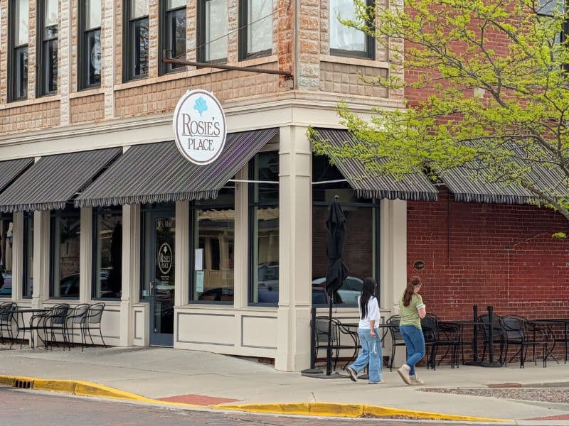 Glass entrance door marked 10 S. Main and the round hanging Rosie's Place sign at the café in downtown Zionsville.