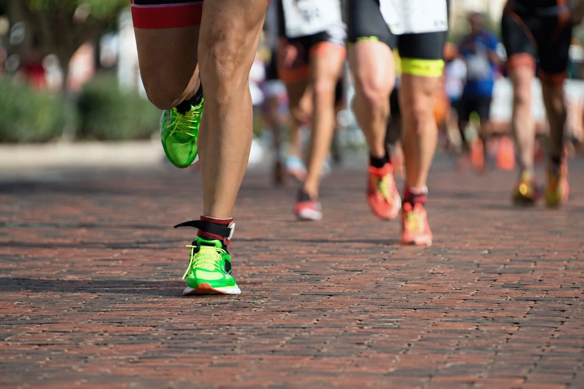 Close-up view of runners' legs and running shoes on the historic brick-paved street during the Hit the Bricks 5K in Zionsville, Indiana.