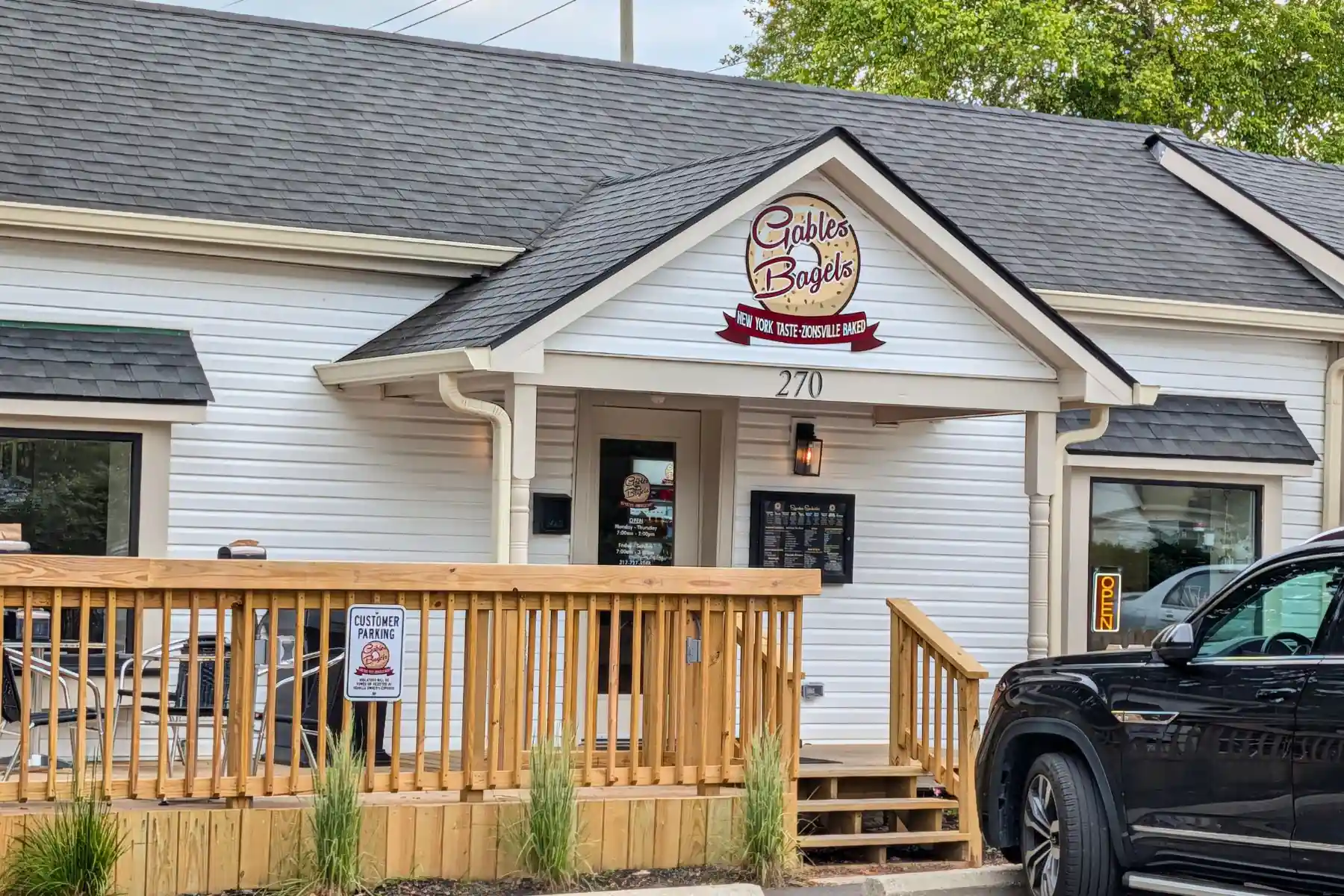 Exterior of Gables Bagels showing the front entrance, wooden porch deck, and storefront sign in Zionsville, Indiana.