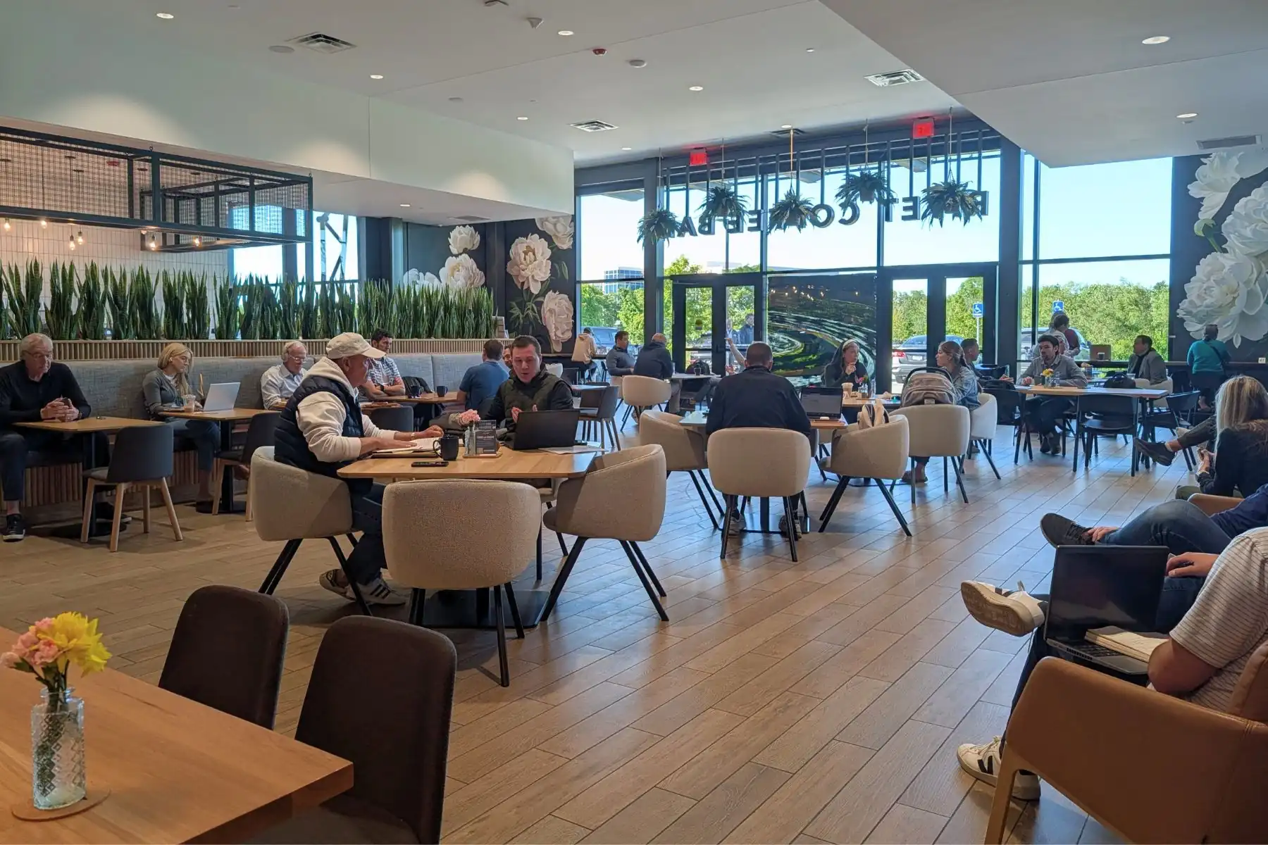 Interior seating area and dining room with guests at RIVET Coffee Bar in Creekside Corporate Park in Zionsville, Indiana.