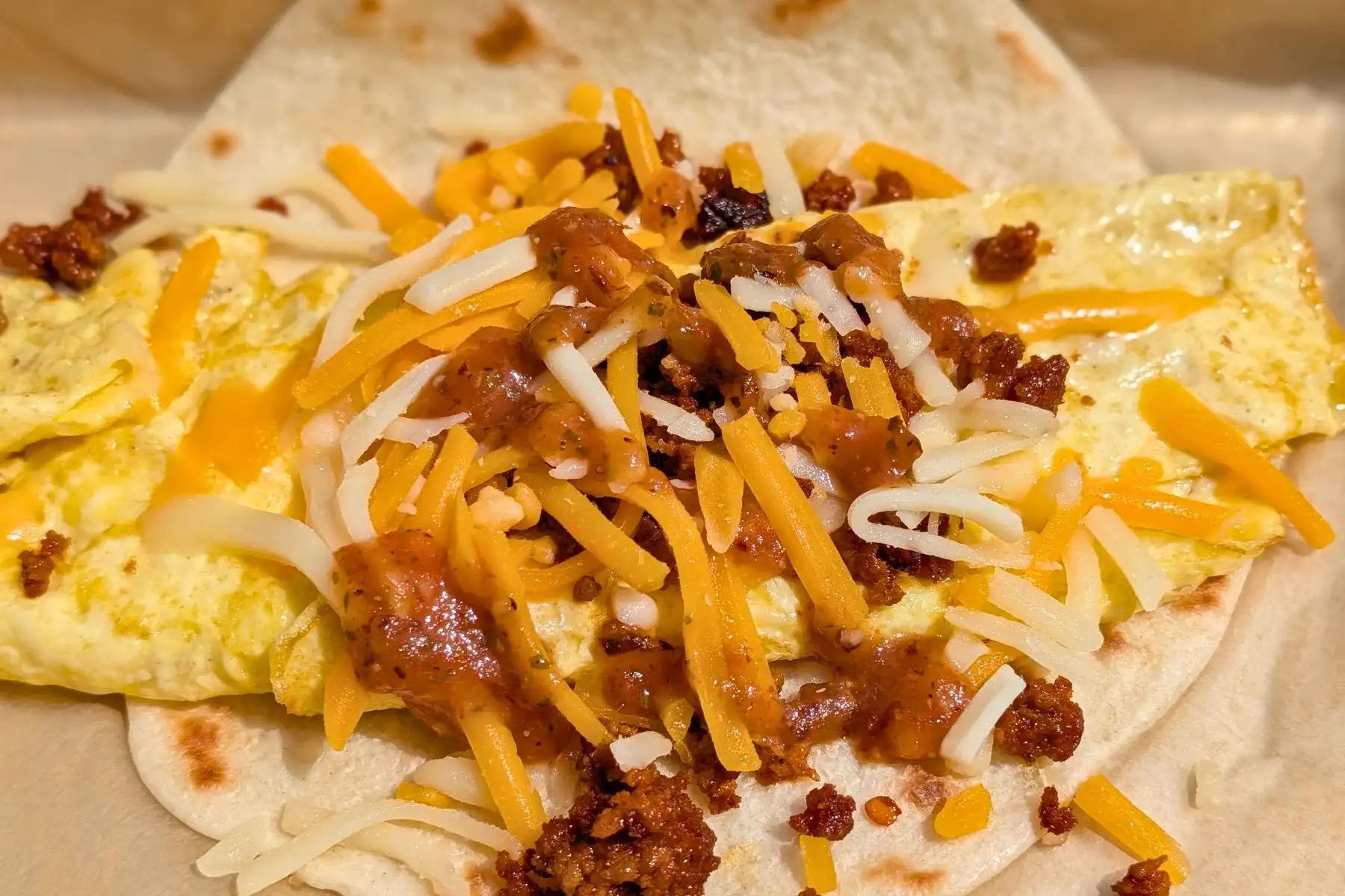 Breakfast taco on a flour tortilla filled with scrambled eggs, chorizo, shredded cheese, and salsa at Torchy's Tacos in Zionsville, Indiana.