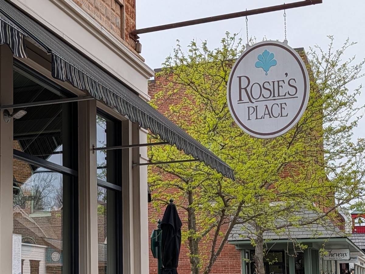 The hanging oval exterior business sign for Rosie’s Place restaurant along the sidewalk in downtown Zionsville.