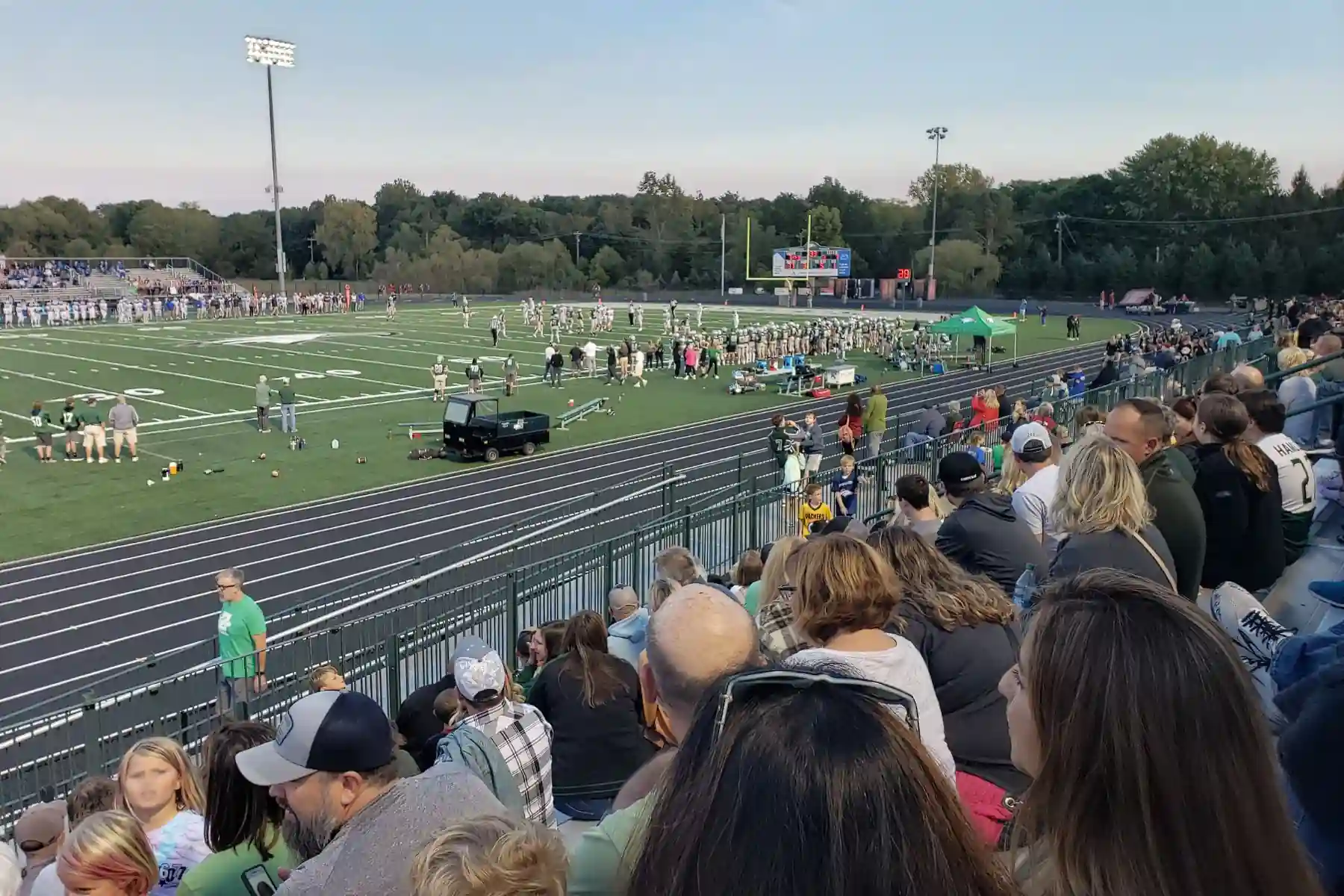 Crowded bleachers at Zionsville Community High School football stadium during a Friday night game.