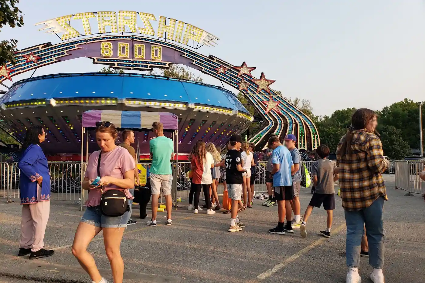 Attendees walking past the Starship 8000 ride entrance at the Zionsville Fall Festival.